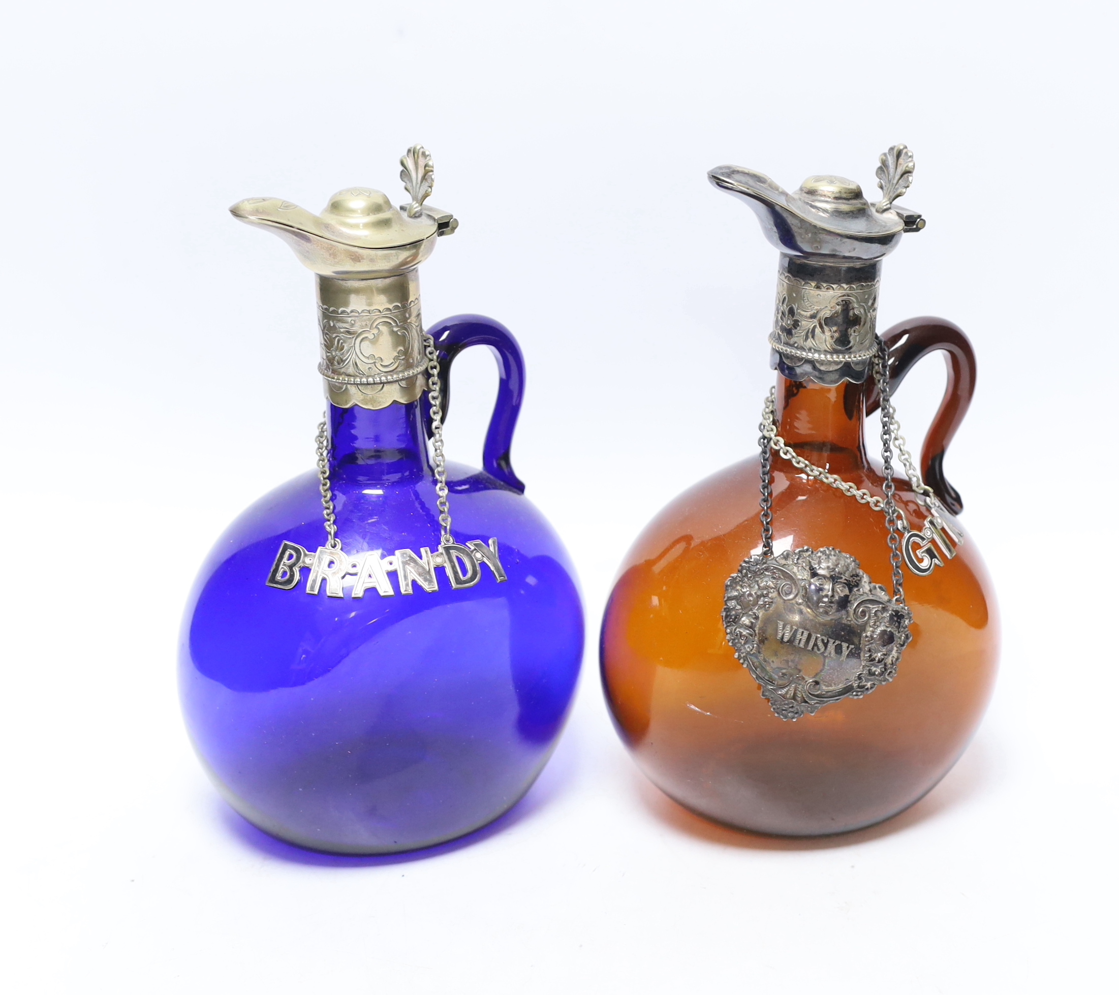 Two Victorian electroplate mounted glass spirit flasks, a silver whisky label and two plated spirit labels